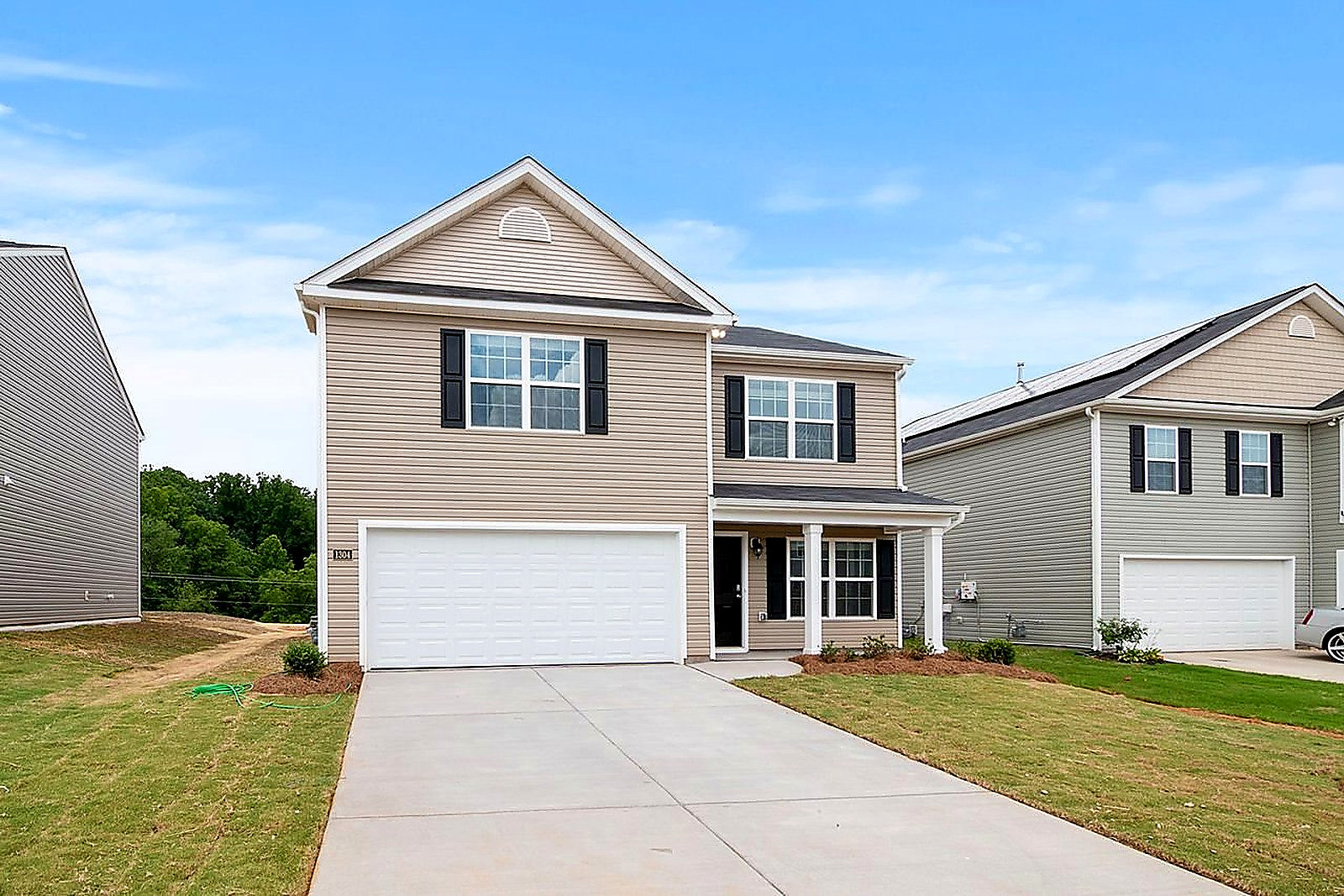 Free Contemporary two-story suburban home with a spacious driveway and lawn. Stock Photo